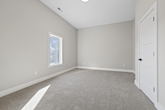 carpeted spare room featuring visible vents and baseboards