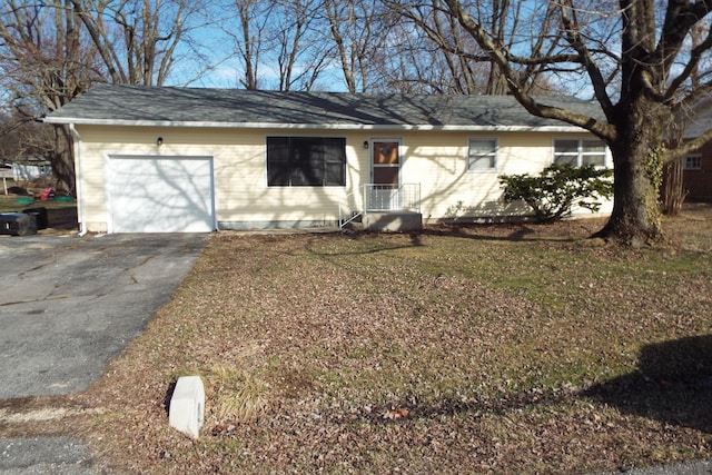 ranch-style house featuring aphalt driveway and an attached garage