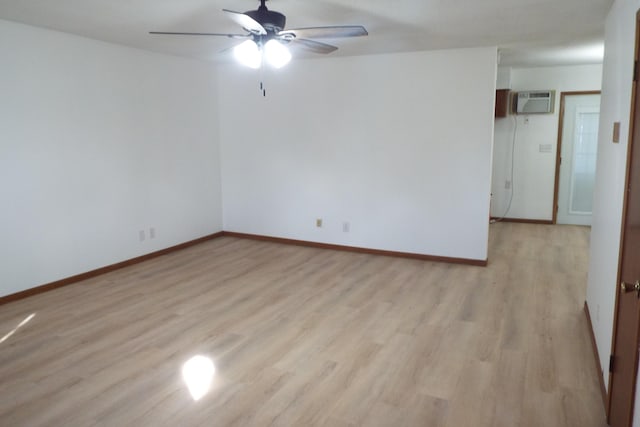 empty room with light wood-style flooring, baseboards, a ceiling fan, and a wall mounted air conditioner