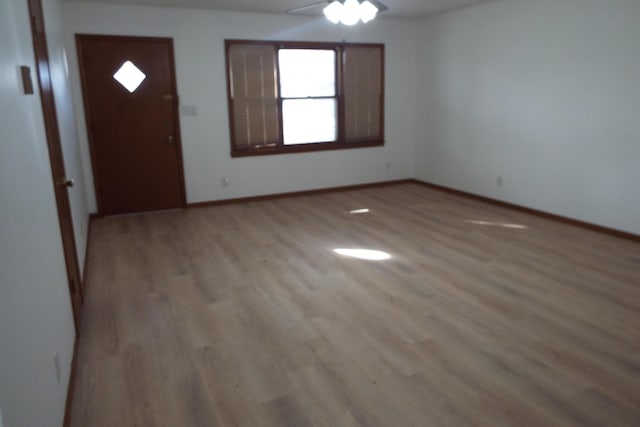 foyer with light wood-style floors, ceiling fan, and baseboards