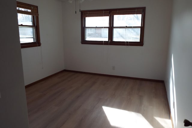 spare room with wood finished floors and baseboards