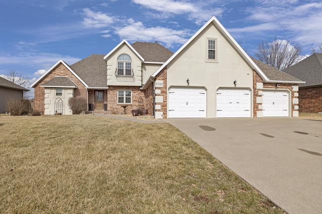 view of front of property featuring roof with shingles, brick siding, stucco siding, a front yard, and driveway