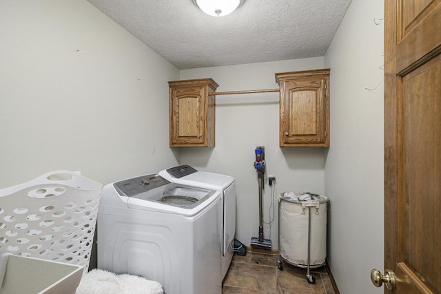 laundry room with cabinet space, washer and clothes dryer, and a textured ceiling