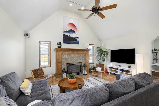 living room featuring high vaulted ceiling, wood finished floors, a high end fireplace, and a wealth of natural light