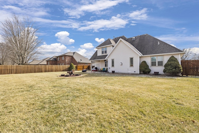 back of property featuring a fenced backyard, a fire pit, a lawn, and a patio