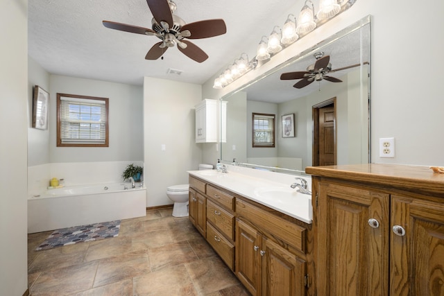 full bath featuring a garden tub, double vanity, a sink, and toilet