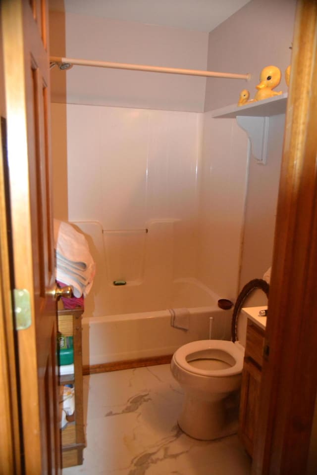 bathroom with  shower combination, marble finish floor, and toilet