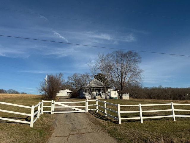 view of gate with a fenced front yard and a rural view