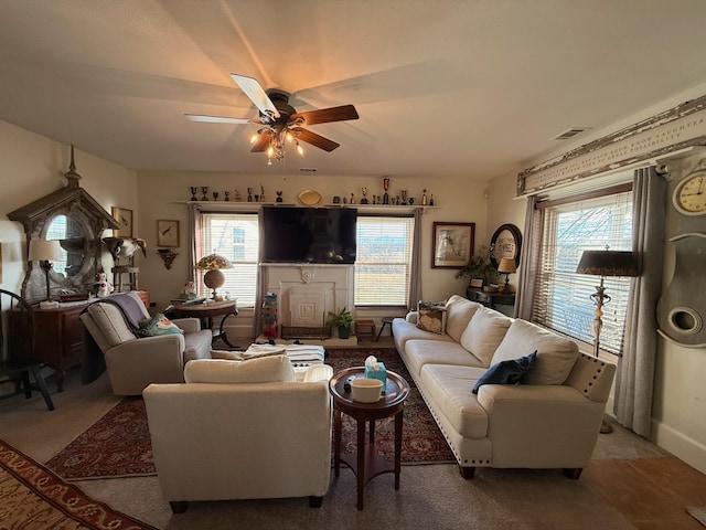 living room with ceiling fan, visible vents, and a wealth of natural light