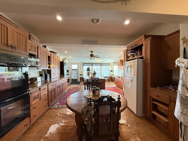 kitchen featuring dobule oven black, stainless steel microwave, open shelves, and freestanding refrigerator