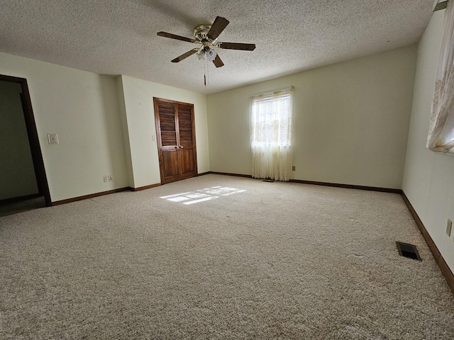 unfurnished bedroom with a closet, visible vents, light carpet, a textured ceiling, and baseboards