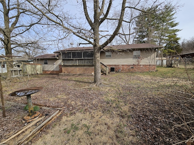 rear view of house with a sunroom, crawl space, and fence