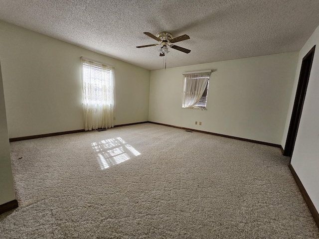 empty room with a ceiling fan, carpet flooring, a textured ceiling, and baseboards