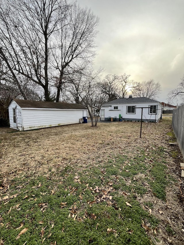 view of yard featuring fence, an outdoor structure, and a storage unit