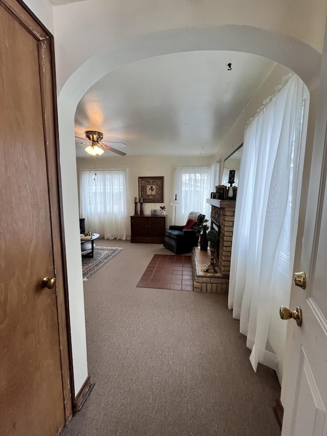 hallway featuring arched walkways and carpet flooring