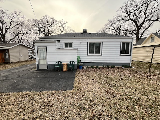 back of property with a chimney