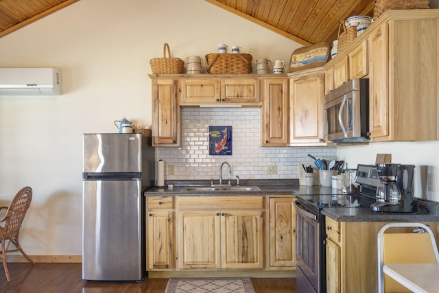 kitchen with dark countertops, appliances with stainless steel finishes, vaulted ceiling, an AC wall unit, and a sink