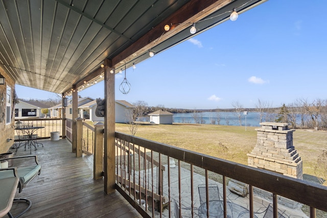 wooden deck with a water view and a yard