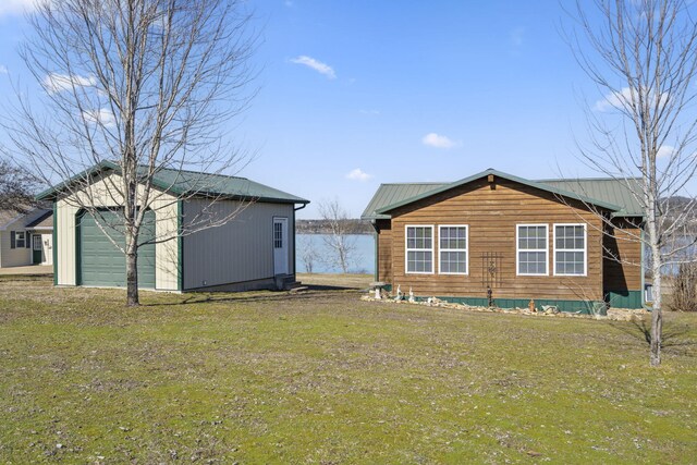 exterior space with a garage, an outbuilding, and a yard