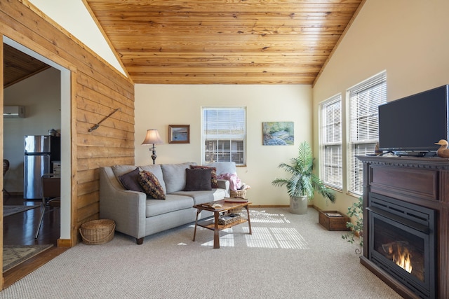 carpeted living room featuring lofted ceiling, a wall unit AC, a glass covered fireplace, and wood ceiling