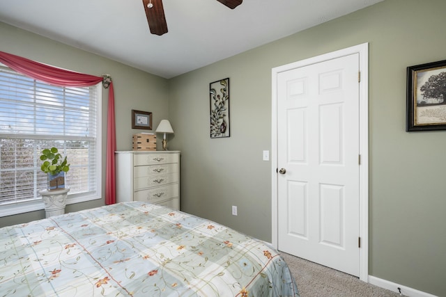 carpeted bedroom featuring ceiling fan and baseboards