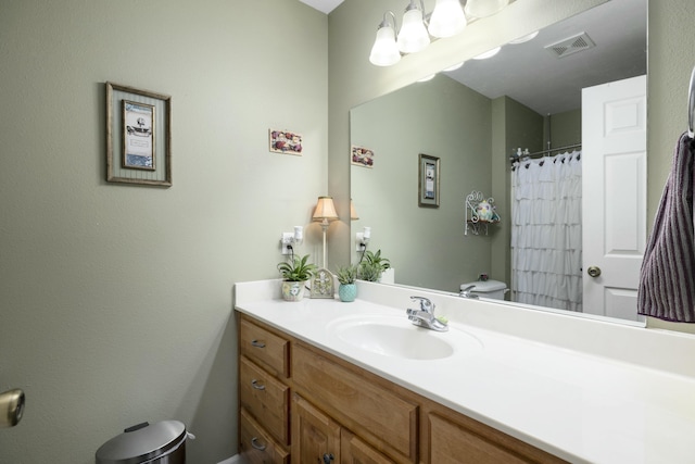 bathroom featuring visible vents, vanity, and toilet