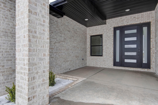 entrance to property featuring brick siding