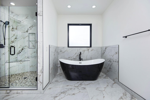 full bath with a freestanding bath, marble finish floor, a marble finish shower, and recessed lighting