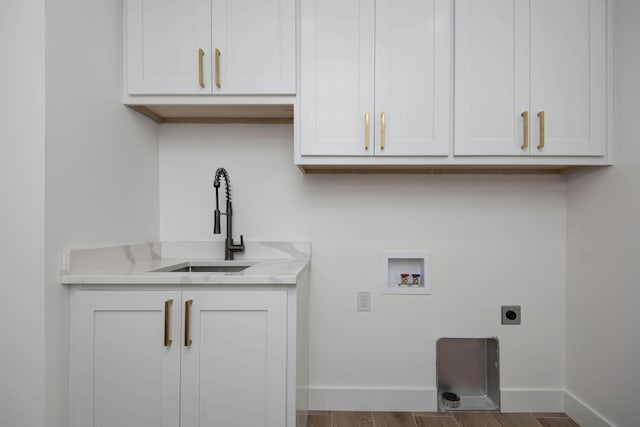 clothes washing area with cabinet space, baseboards, hookup for an electric dryer, washer hookup, and a sink