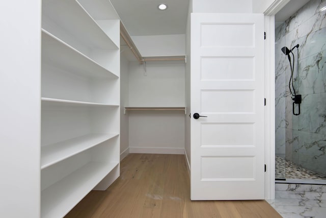 walk in closet with wood finished floors