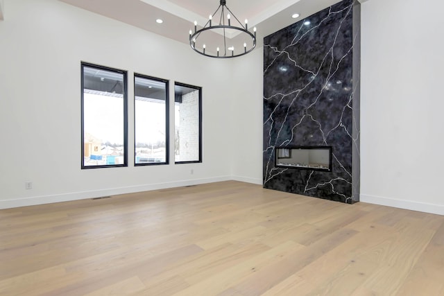 interior space featuring recessed lighting, visible vents, a premium fireplace, wood finished floors, and a chandelier