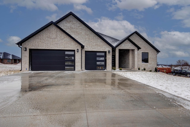 view of front of property with a garage, brick siding, and driveway