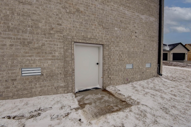 entrance to property featuring crawl space and brick siding