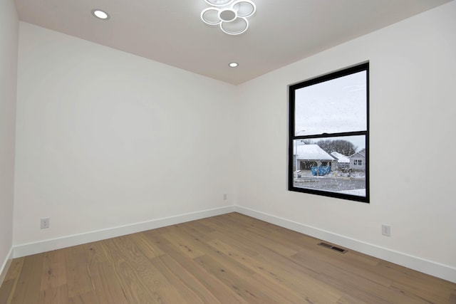 spare room with baseboards, visible vents, wood finished floors, and recessed lighting