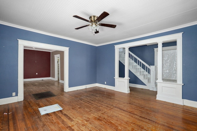 empty room with stairs, crown molding, decorative columns, and hardwood / wood-style flooring