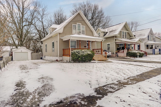 bungalow-style house with covered porch, a detached garage, fence, and an outdoor structure