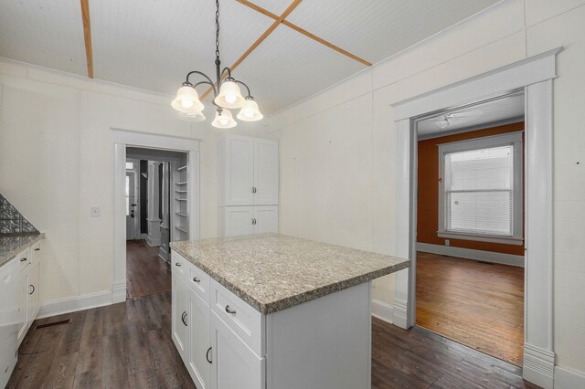 kitchen featuring pendant lighting, dark wood-style flooring, white cabinetry, and a kitchen island