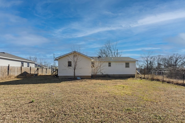 back of property with a yard and fence private yard