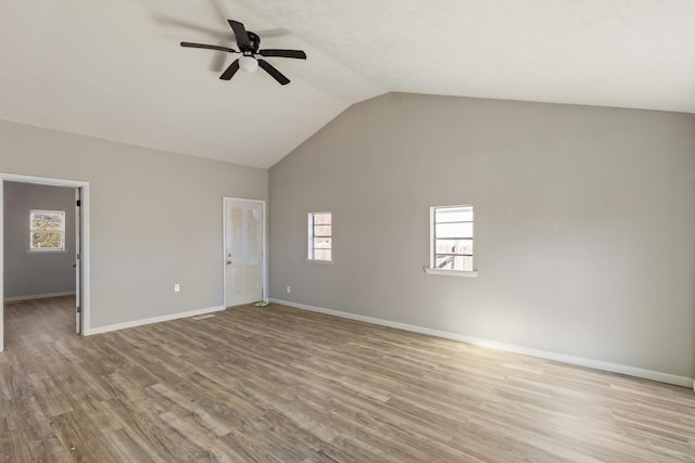 unfurnished room featuring a ceiling fan, baseboards, vaulted ceiling, and wood finished floors