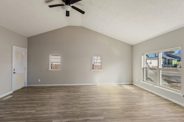 unfurnished room featuring baseboards, vaulted ceiling, and wood finished floors