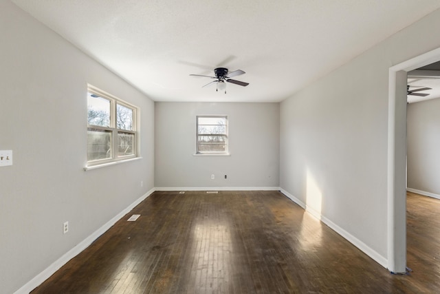 empty room featuring a ceiling fan, baseboards, and hardwood / wood-style floors