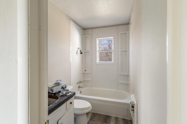 bathroom featuring shower / bath combination, toilet, vanity, a textured ceiling, and wood finished floors