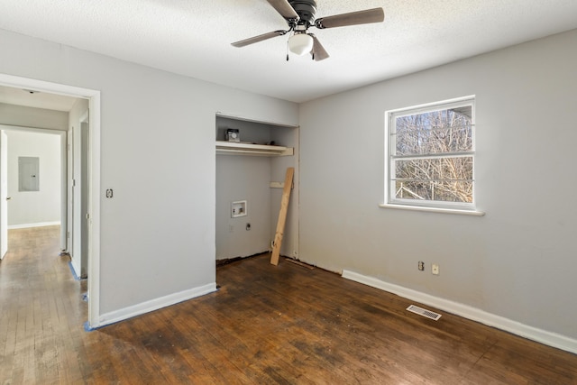 unfurnished bedroom featuring baseboards, electric panel, visible vents, and hardwood / wood-style floors