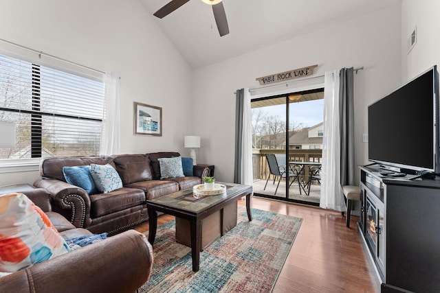 living area with ceiling fan, visible vents, high vaulted ceiling, and wood finished floors