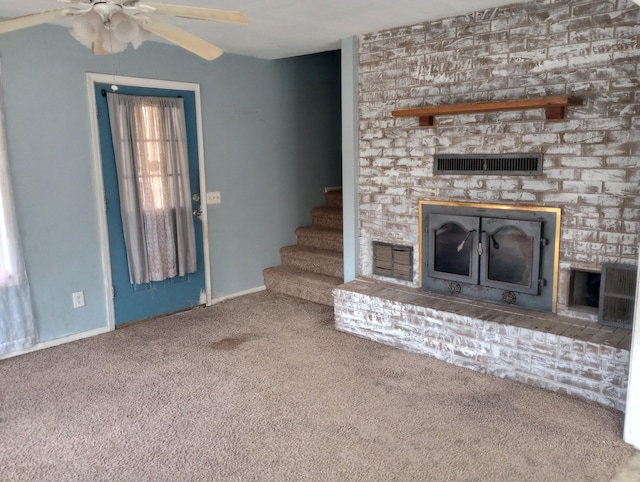 unfurnished living room featuring carpet floors, visible vents, a fireplace, and a ceiling fan