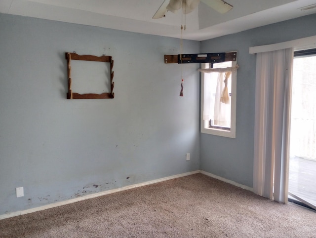 carpeted empty room with a ceiling fan, visible vents, and baseboards