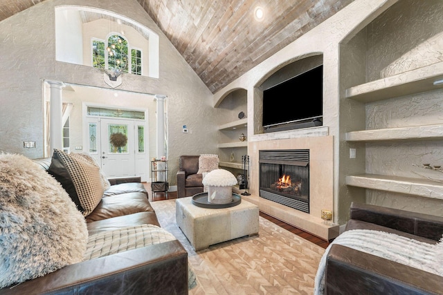 living area featuring built in features, a textured wall, wood ceiling, wood finished floors, and a lit fireplace