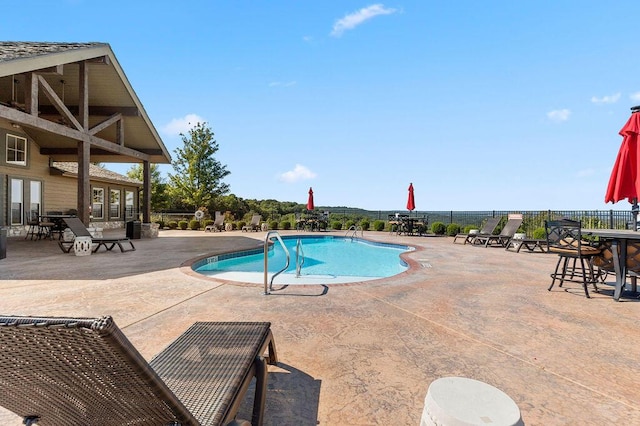 community pool featuring a patio area and fence