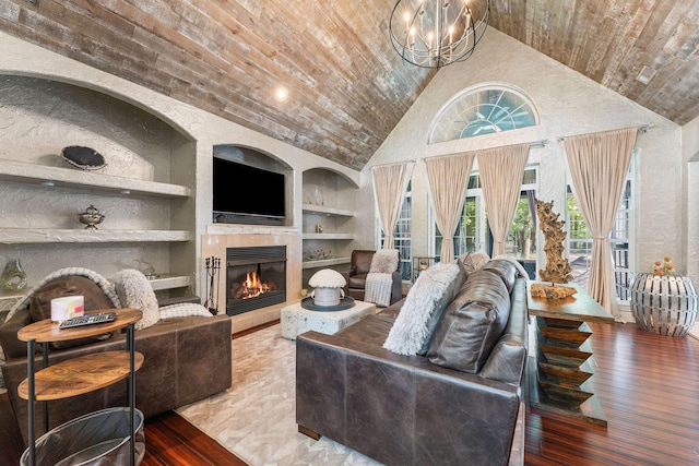 living room with high vaulted ceiling, wooden ceiling, a tile fireplace, built in features, and hardwood / wood-style floors