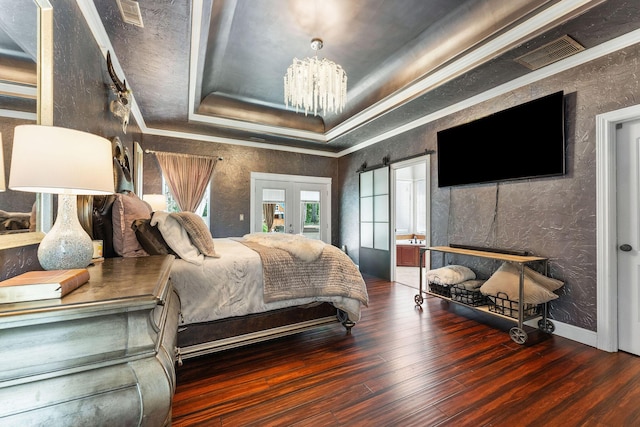 bedroom with french doors, a raised ceiling, visible vents, a chandelier, and hardwood / wood-style floors